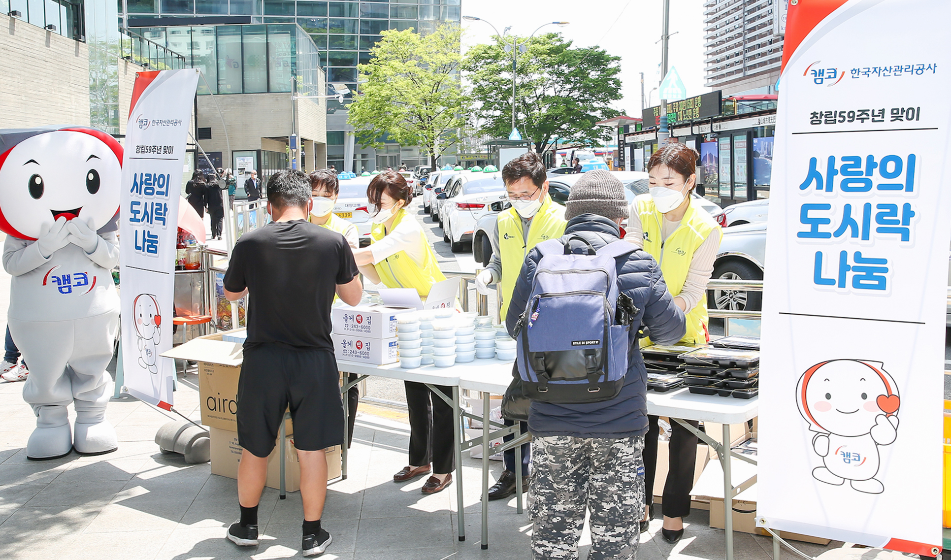 4월 28일(수) 부산역 광장에서 캠코 직원들이 창립 59주년 기념행사의 일환으로 복지 사각지대의 노숙인에게 도시락 및 마스크를 나누는 봉사활동을 펼치고 있다.