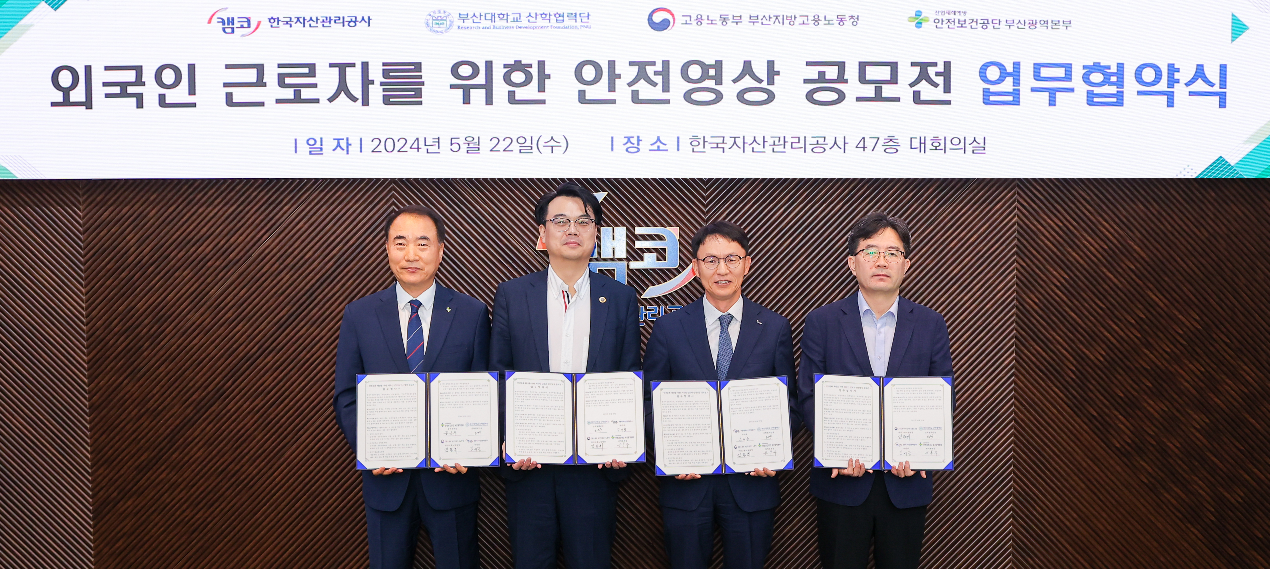 5월 22일(수) 부산국제금융센터(부산 남구 문현동) 대회의실에서 개최한 「외국인 근로자를 위한 안전영상 공모전 업무협약식」에서 김서중 캠코 부사장(사진 오른쪽에서 두 번째), 손영기 부산지방고용노동청 산재예방지도과장(사진 오른쪽에서 첫 번째), 오진우 부산대학교 산학협력단 산학기획부단장(사진 오른쪽에서 세 번째), 공흥두 한국산업보건공단 광역본부장(사진 오른쪽에서 네 번째)이 기념촬영을 하고 있다.