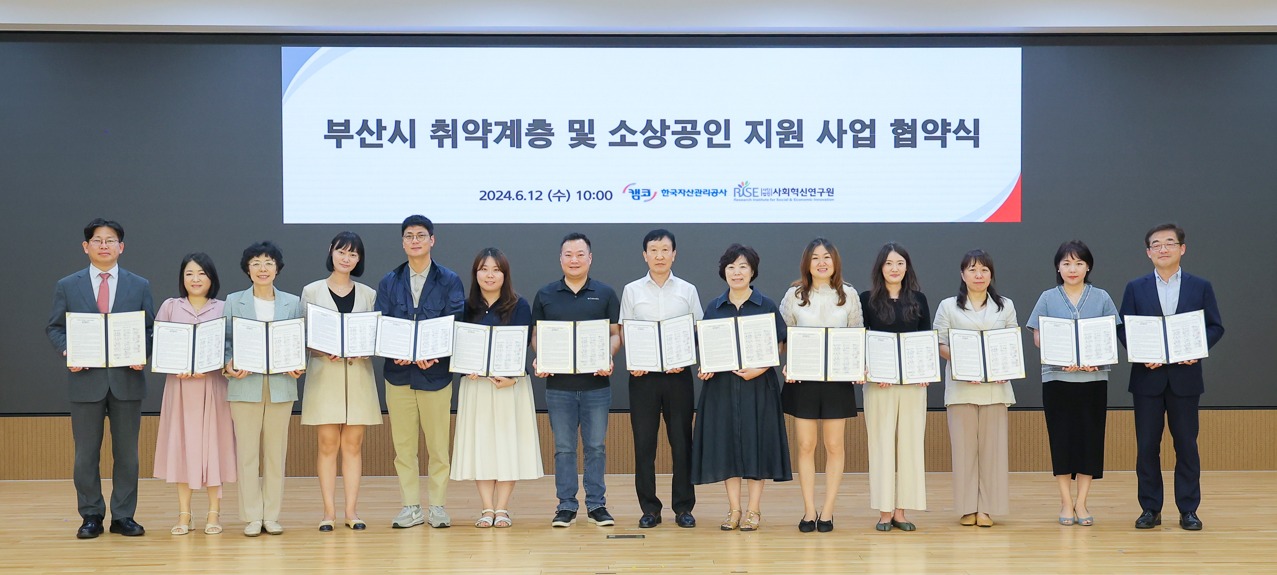 6월 12일(수) 부산국제금융센터(BIFC) 3층 캠코마루에서 열린 「부산광역시 취약계층 및 소상공인 지원 사업 참여기관 업무협약식」에서 참여기관 관계자들이 협약을 체결하고 기념촬영을 하고 있다.