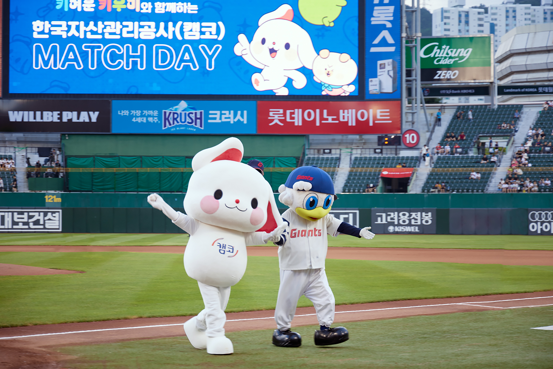 8월 6일(화) 부산 롯데 사직구장에서 캠코의 마스코트 캐릭터 '키우미'(사진 왼쪽)가 관중들에게 인사를 하고 있다.