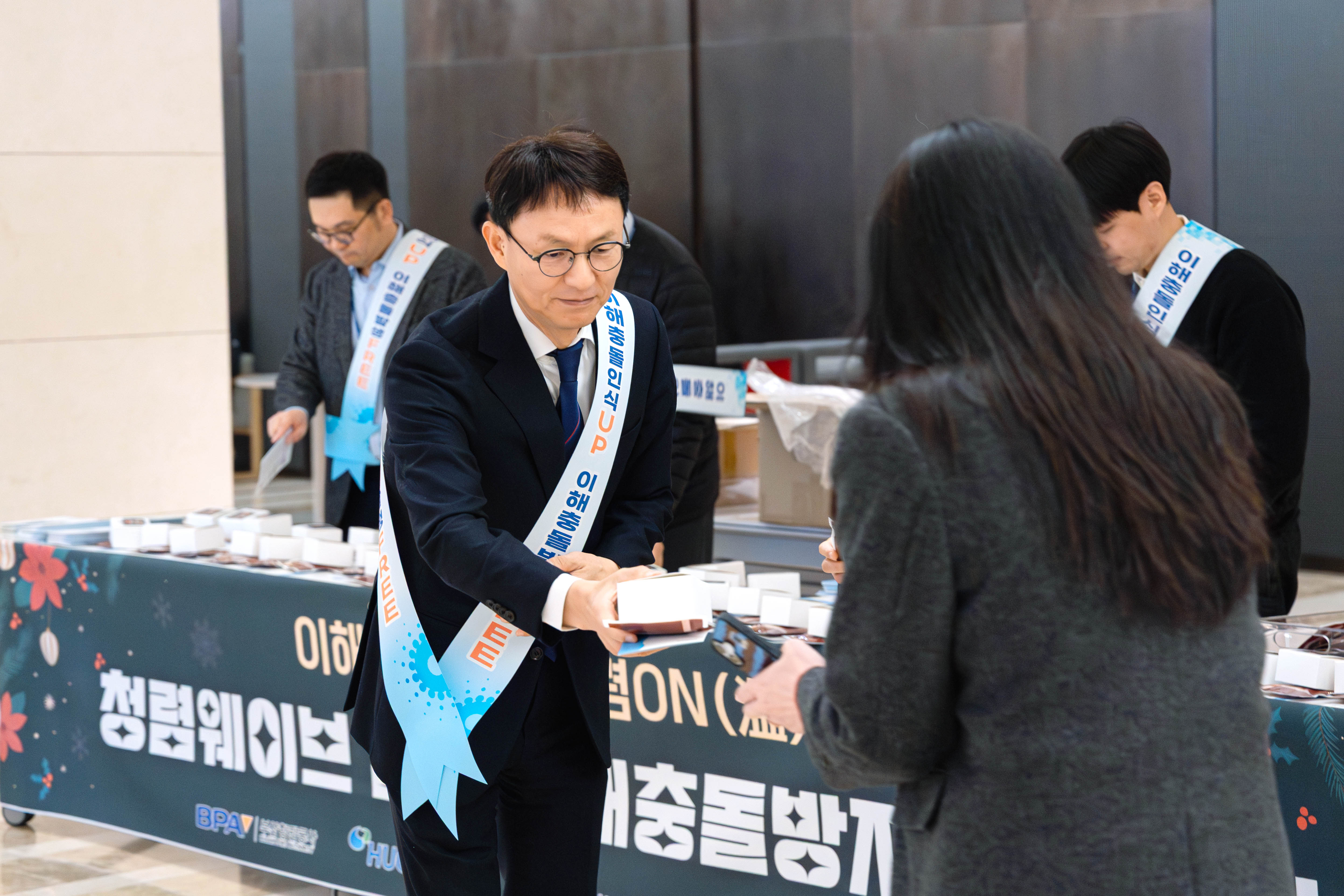 12월 17일(수) 부산국제금융센터(BIFC) 1층 로비에서 김서중 캠코 부사장이 출근 중인 공공기관 직원에게 청렴 쿠키를 배부하고 있다.